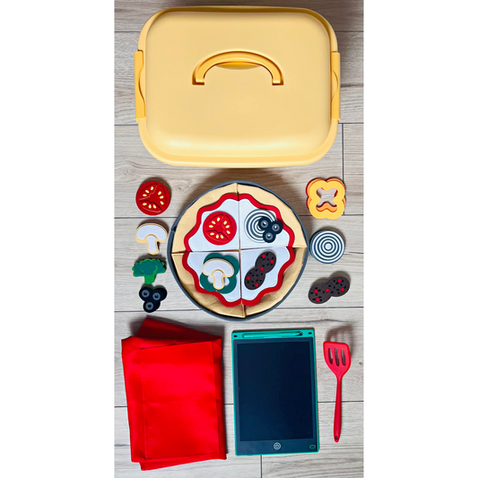 Playset with toy pizza, toppings, and kitchen utensils on a wooden surface