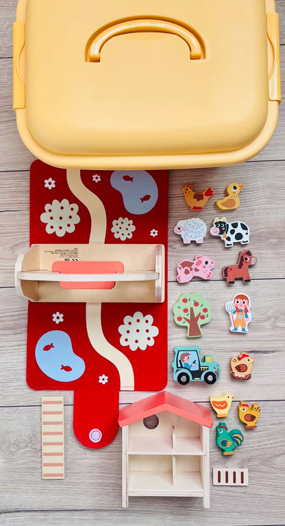 A yellow bin with wooden farm animals, a barn, a green tractor, and a chicken coop.