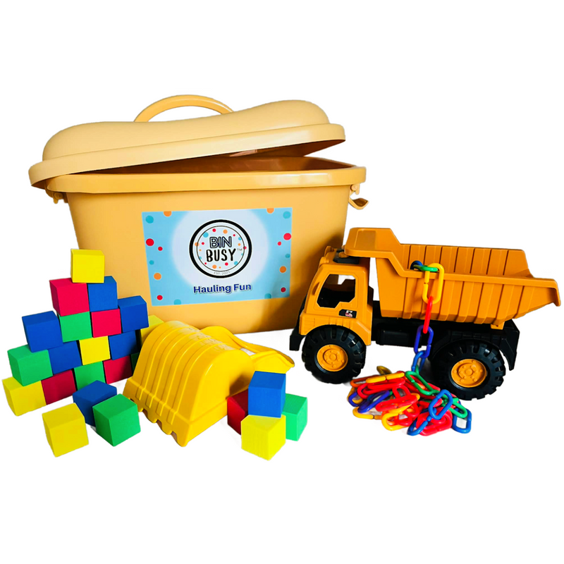 Picture of a yellow bin, a dump truck, colorful foam blocks, plastic links, and a yellow hand shovel.